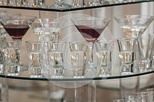 Different alcohol drinks on a glass stand. wine, champagne, cognac, vodka, martini