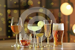 Different alcohol drinks on wooden table indoors