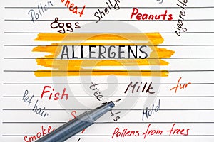 Different allergens written on lined paper and pen