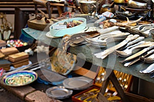 Different antiques on flea market or festival - vintage silver cultery - spoons, knifes, forks and other vintage things.