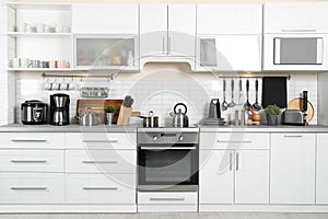 Different appliances, clean dishes on kitchen counter