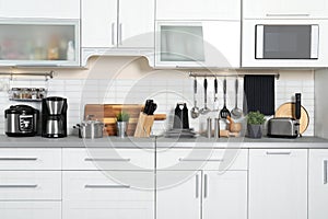 Different appliances, dishes and utensils on kitchen counter