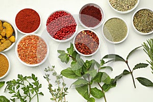 Different aromatic spices and herbs on white background, flat lay