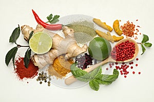 Different aromatic spices, lime and herbs on white background, flat lay