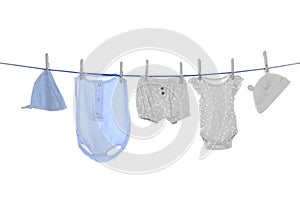 Different baby clothes drying on laundry line against white background