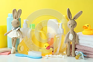 Different baby hygiene accessories against yellow background