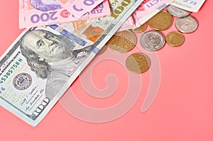 Different banknotes and coins on pink background. Payment of pensions, salaries