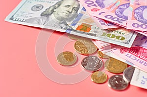 Different banknotes and coins on pink background. Payment of pensions, salaries