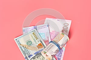 Different banknotes on pink background. Payment of pensions, salaries