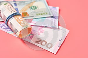 Different banknotes on pink background. Payment of pensions, salaries