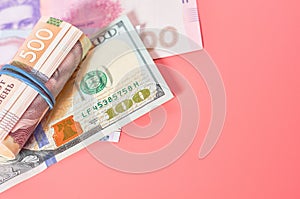 Different banknotes on pink background. Payment of pensions, salaries