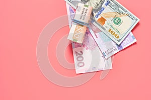 Different banknotes on pink background. Payment of pensions, salaries