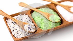 Different bath salts with wooden spoons on tray