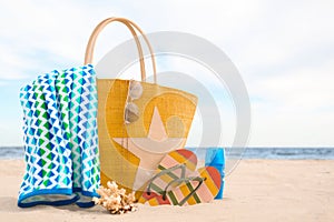 Different beach objects and coral on sand near sea