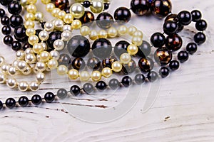 Different beads necklaces on white wooden background