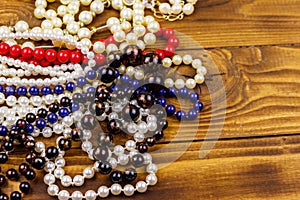 Different beads necklaces on wooden background