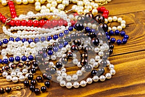 Different beads necklaces on wooden background