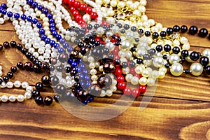 Different beads necklaces on wooden background