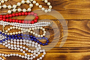 Different beads necklaces on wooden background