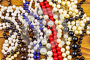 Different beads necklaces on wooden background