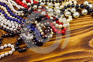 Different beads necklaces on wooden background