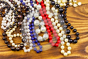 Different beads necklaces on wooden background