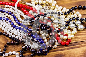 Different beads necklaces on wooden background