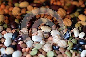 Different beans scattered on a wooden surface closeup. Naturel organic food background