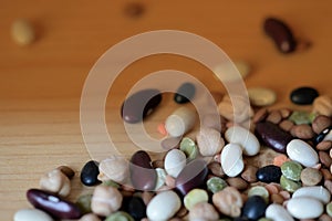 Different beans scattered on a wooden surface closeup. Naturel organic food background