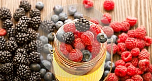 Different berries in a basket on a wooden table