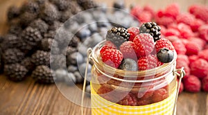 Different berries in a basket on a wooden table