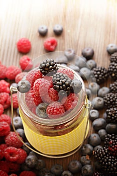 Different berries in a basket on a wooden table