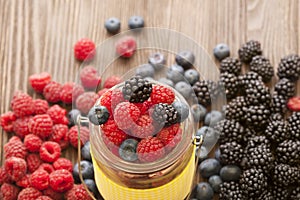 Different berries in a basket on a wooden table