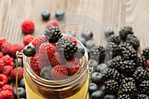 Different berries in a basket on a wooden table