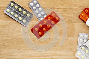 Different blister pack with round pills on a wooden table