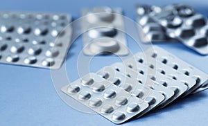 Different blister of pills. Medical and Global healthcare concept. Pharmaceutical industry. Light blue paper background