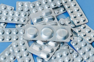 Different blister of pills. Medical and Global healthcare concept. Pharmaceutical industry. Light blue paper background