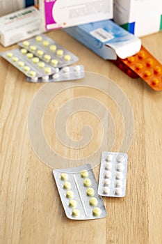 Different blisters pack with tablets on a wooden table
