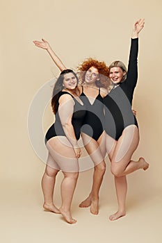 Different Body Types. Group Of Diversity Models Full-length Portrait. Blonde, Brunette And Redhead In Black Bodysuits Posing. photo