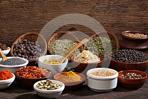 Different bowls of spices over a wooden background