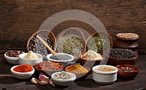 Different bowls of spices over a wooden background