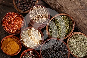 Different bowls of spices over a wooden background