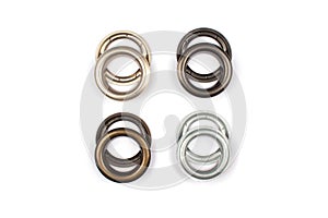 Different brass multicoloured metal eyelets or rivets - curtains rings for fastening fabric to the cornice, isolated on