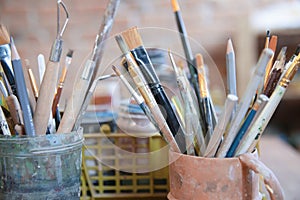 Different brushes in drawing studio interior. Close up view .