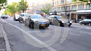 Different cars drive down the street and stop in front of the pedestrian crossing