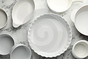 Different casseroles on white marble table, flat lay