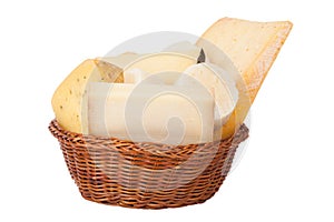 Different cheeses and a bunch of parsley lying in a wicker basket isolated on white background