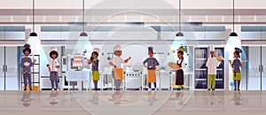 Different chefs standing together african american men women r in uniform cooking food concept modern restaurant kitchen