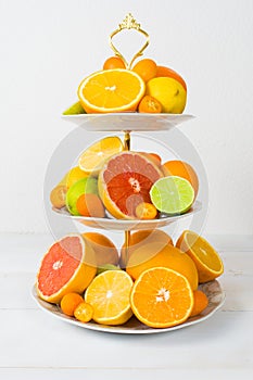 Different citrus fruit on cake stand with copy space