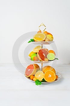 Different citrus fruit on cake stand with copy space